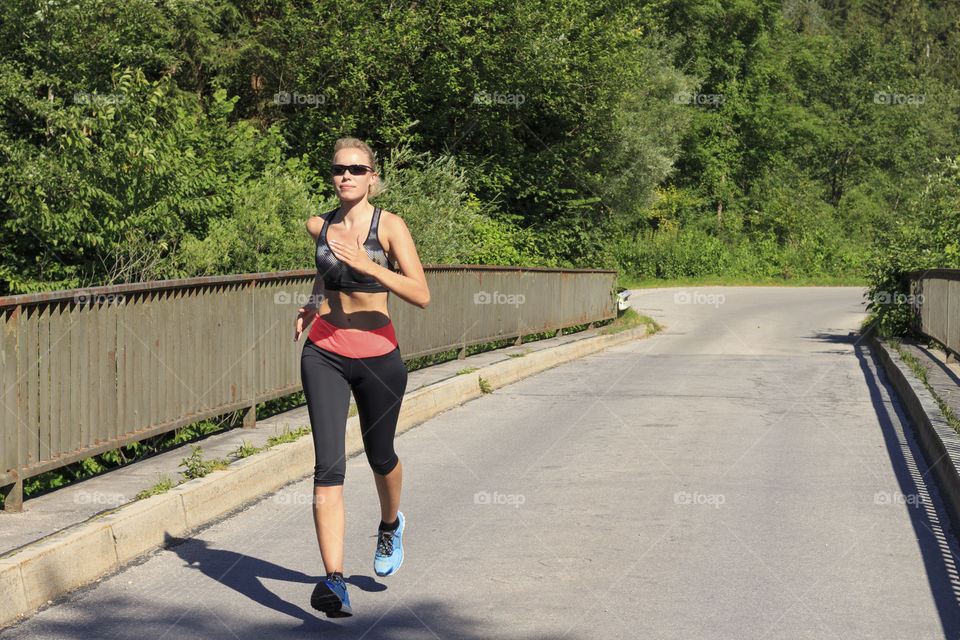 Young woman jogging on bridge