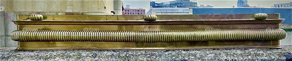 A decorative bronze fireplace fender found in Manhattan’s Upper East Side and transported here to Newtown Creek in LIC, Queens was photographed right away in the parking lot beneath the Pulaski Br against the Greenpoint, Bklyn shore. 2022. Hypnotic P