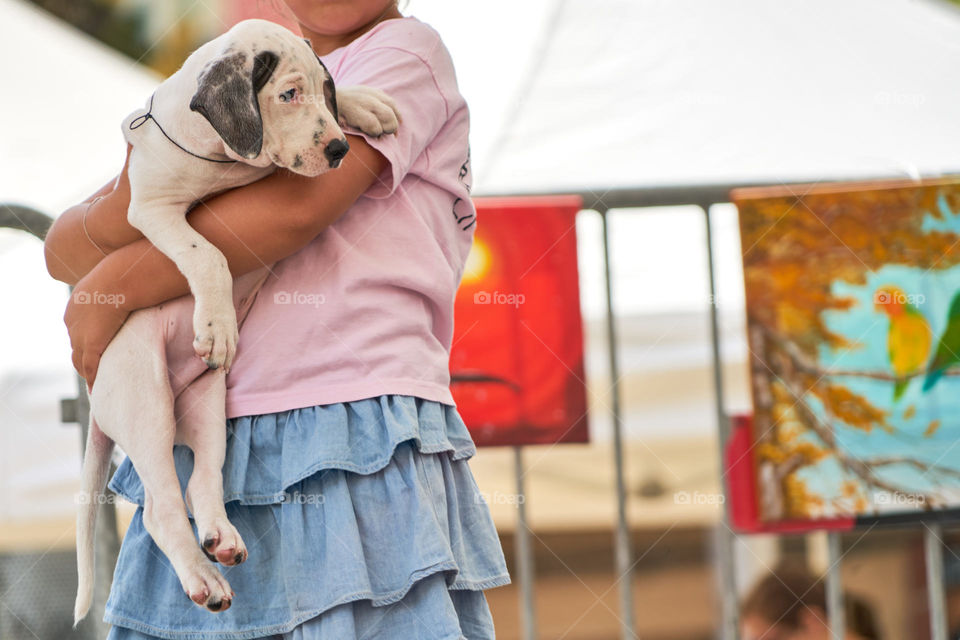 Side view of a girl carrying a dog