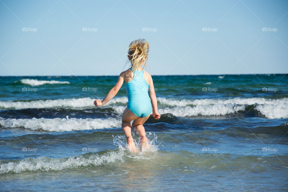 Two young sisters age five and three playing on the beach in Höllviken in Sweden.