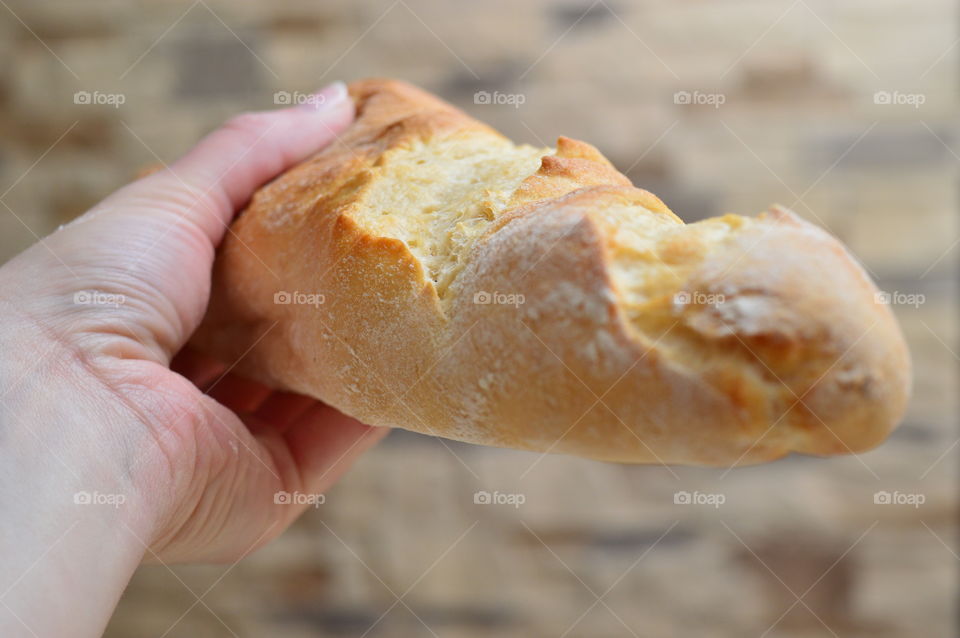 Close-up of hand holding baguette