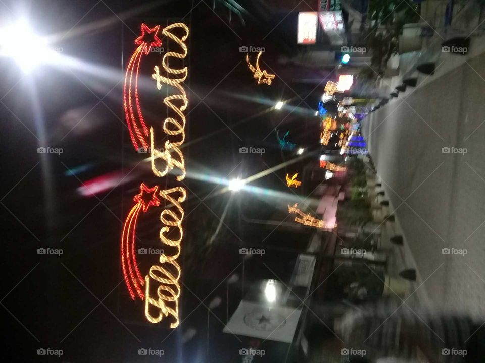 importante avenida de pueblo adornada con luces navideñas en forma de palabras haciendo alusión a las fiestas