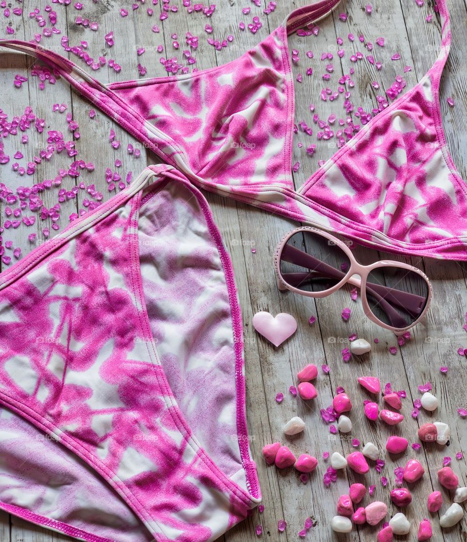 Pink bikini and sunglasses flat lay 