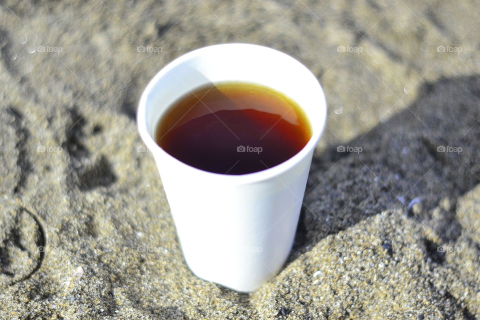 Coffee on disposable cup at beach