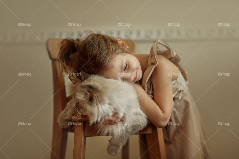 Vintage portrait of a beautiful little girl with rag-doll cat