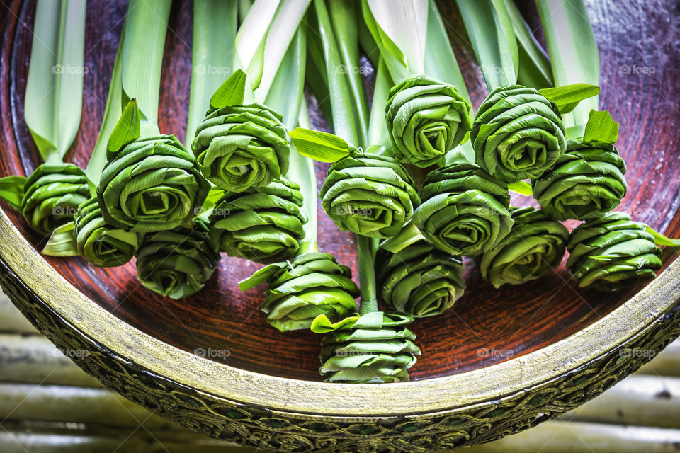 Spa therapy with green artificial flowers in bowl