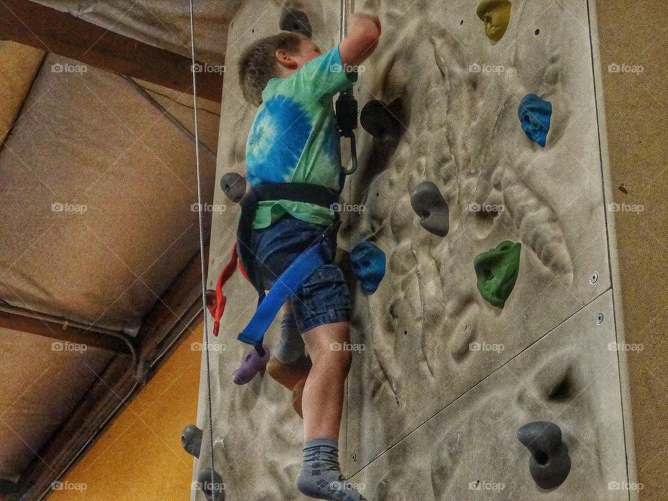 Boy Climbing A Rock Wall