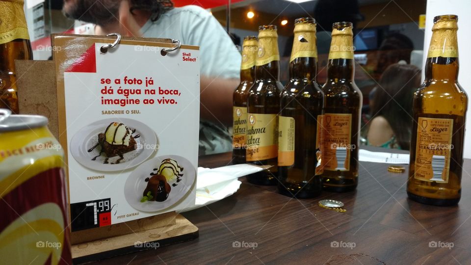 Mesa de conveniência com long necks de cervejas.