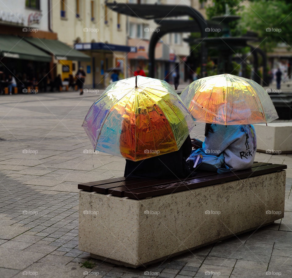 Two umbrellas on a bench