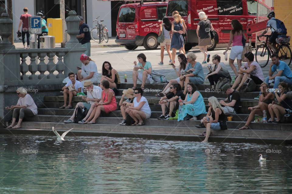 Snack Time. People having snacks by the Reuss river in Luzern.