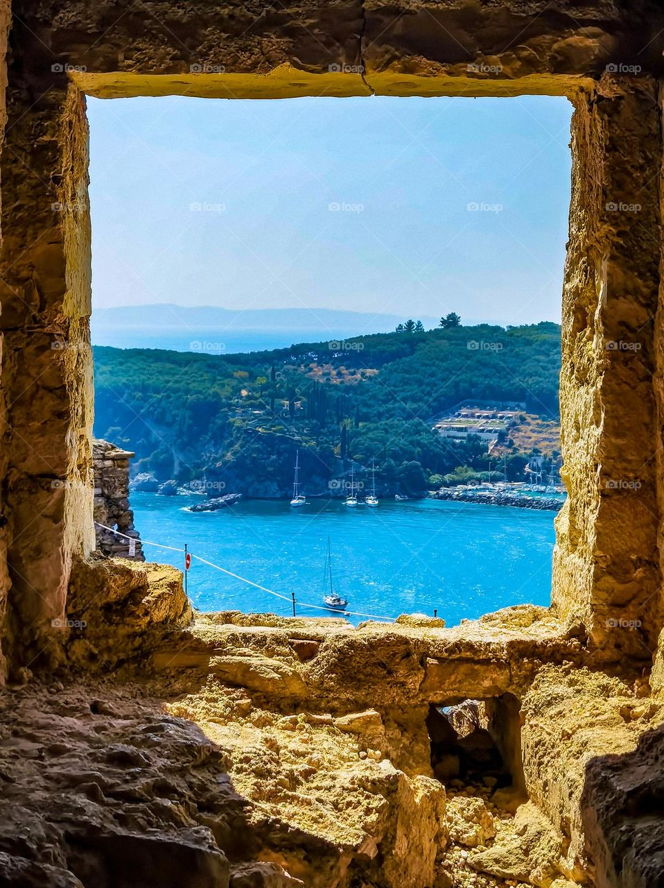 Frame inside of frame. Beautiful city of Parga in Greece framed by a window on the castle.