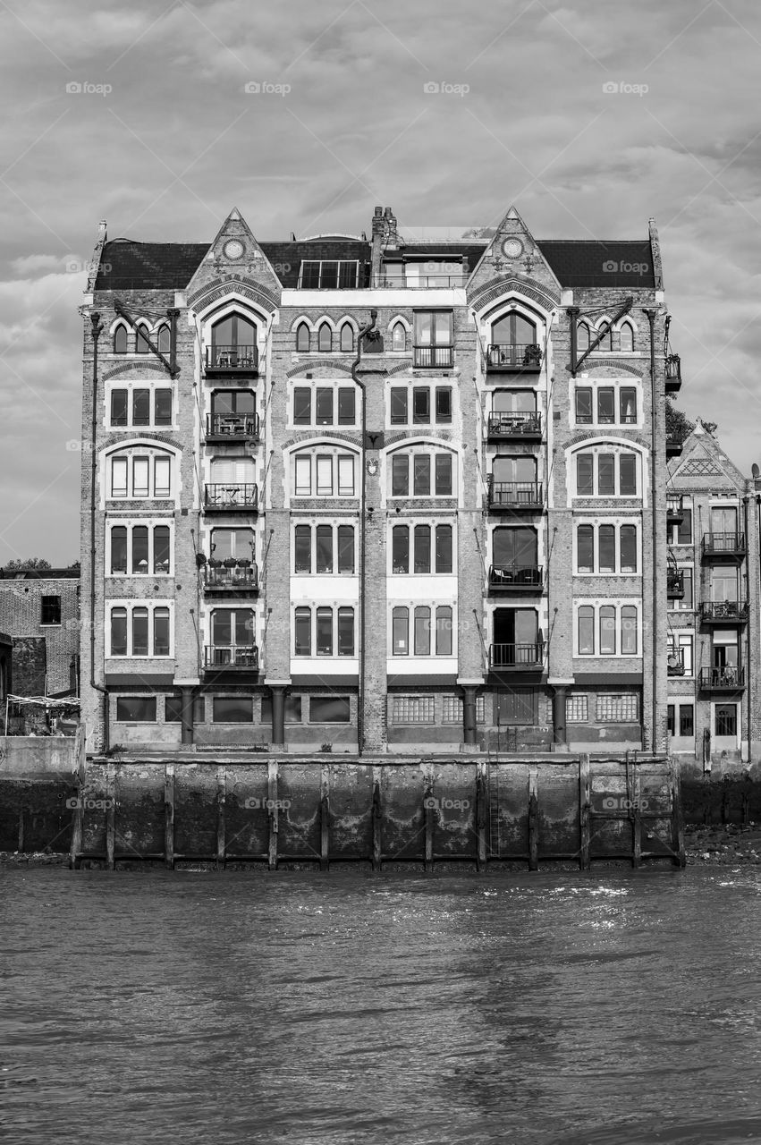 Old Victorian wharf building adopted for residential dwelling on banks of river Thames. London, UK.
