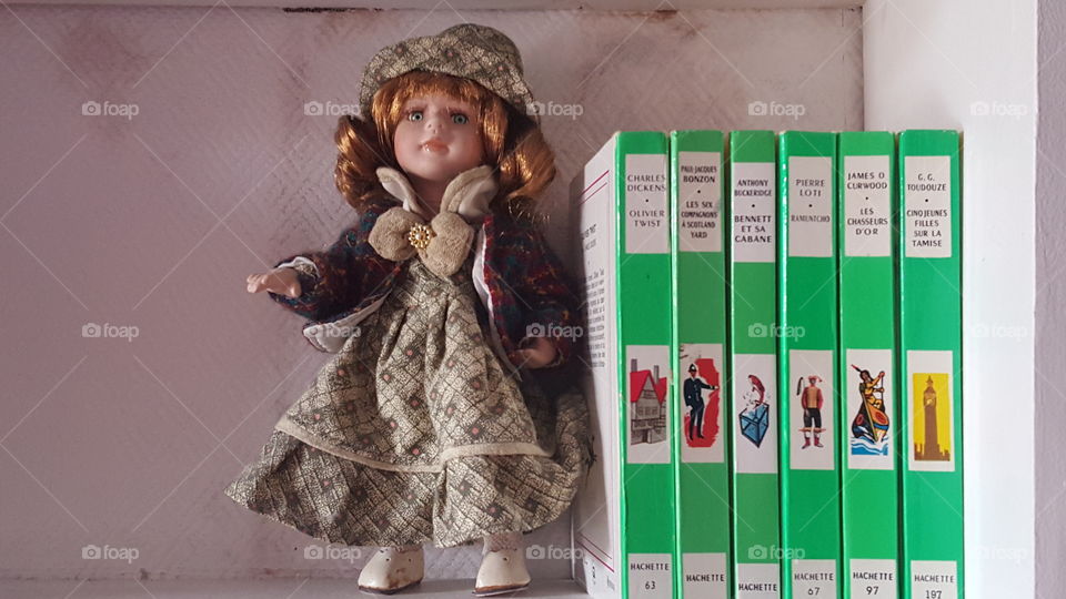 old doll with books