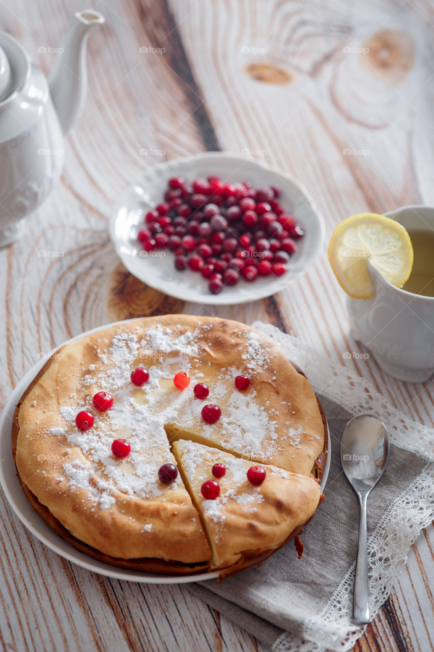 Cheesecake with cranberries and sugar on wooden background