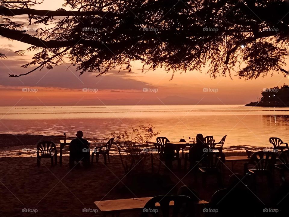 Sunset by the beach, a pink and orange sky