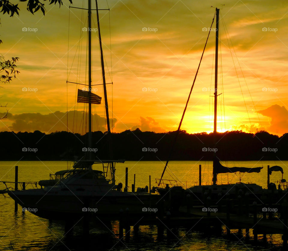 Silhouette of sailboat at yacht during sunset