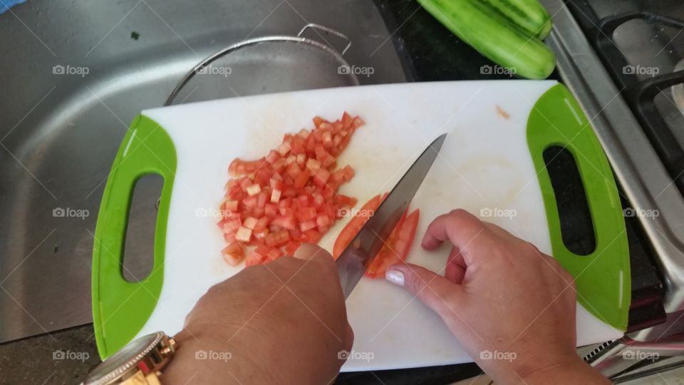 personal point of view, cutting tomato on a cutting board