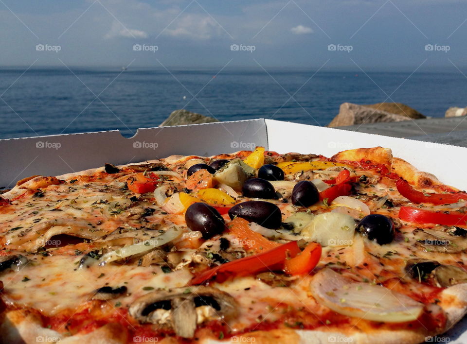 Enjoying pizza by the ocean.