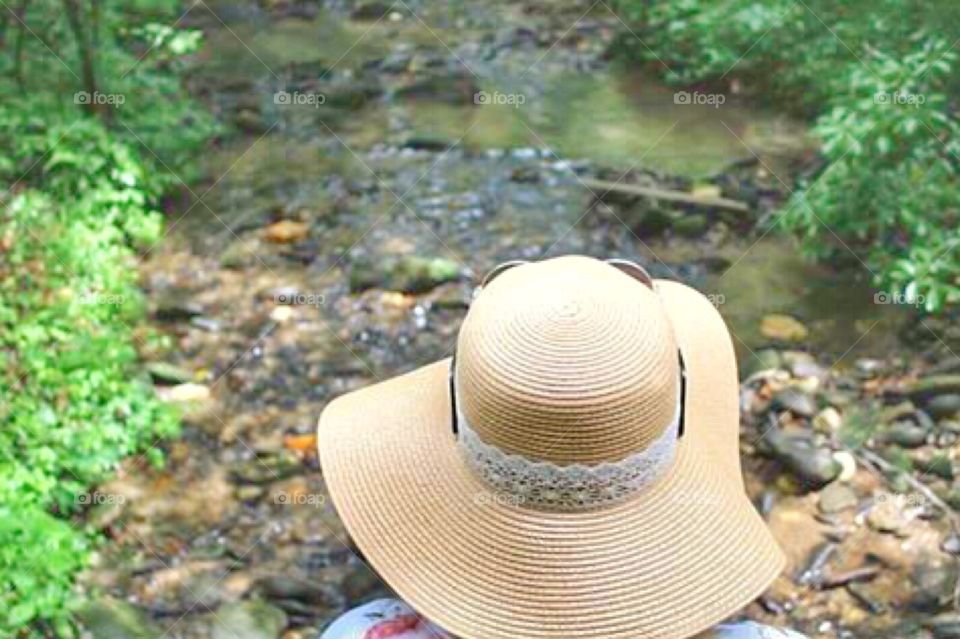 A woman sitting by a stream 