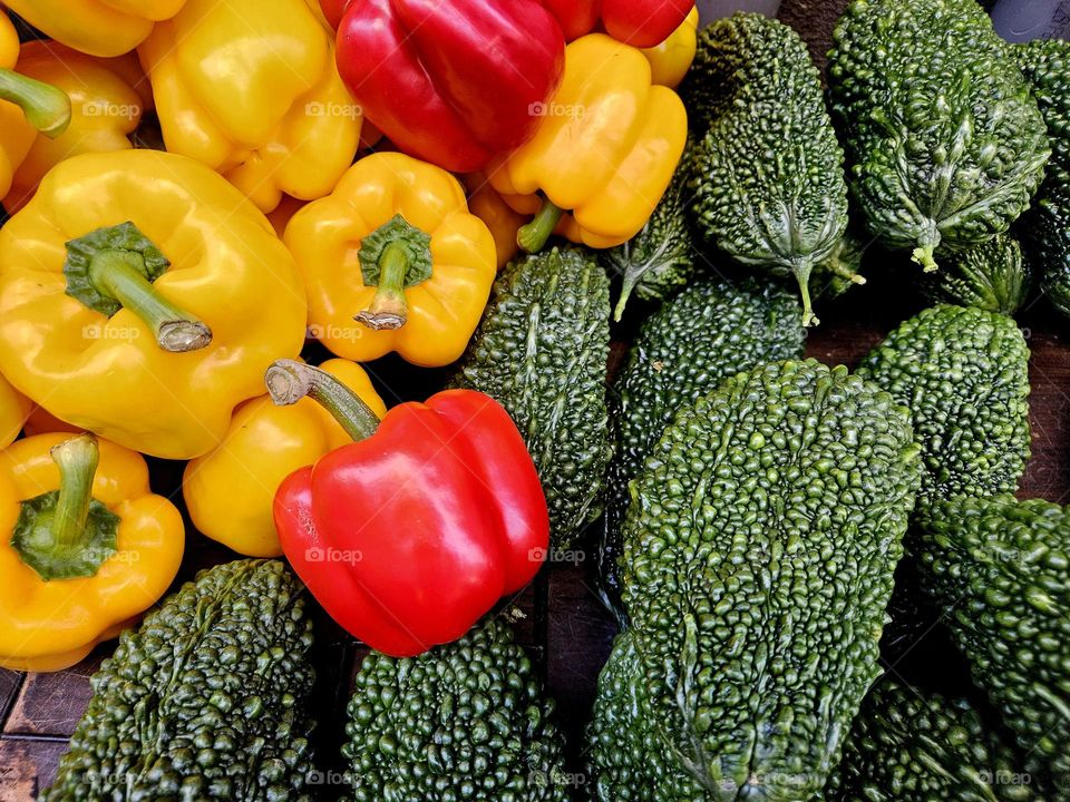 Fresh fruits and vegetables, bitter gourd and red and yellow peppers