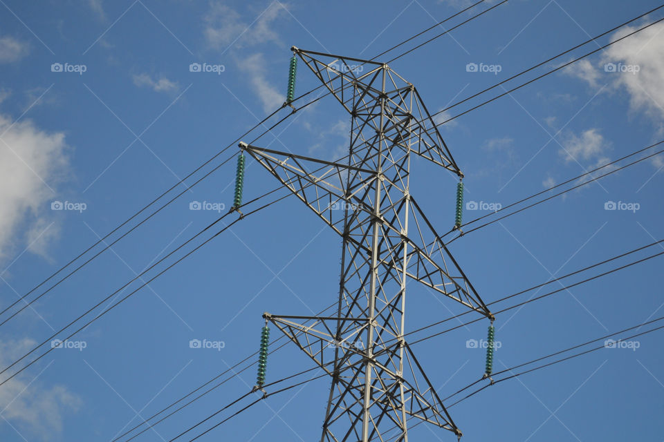 Symmetry in electrical pole; against vivid blue sky 