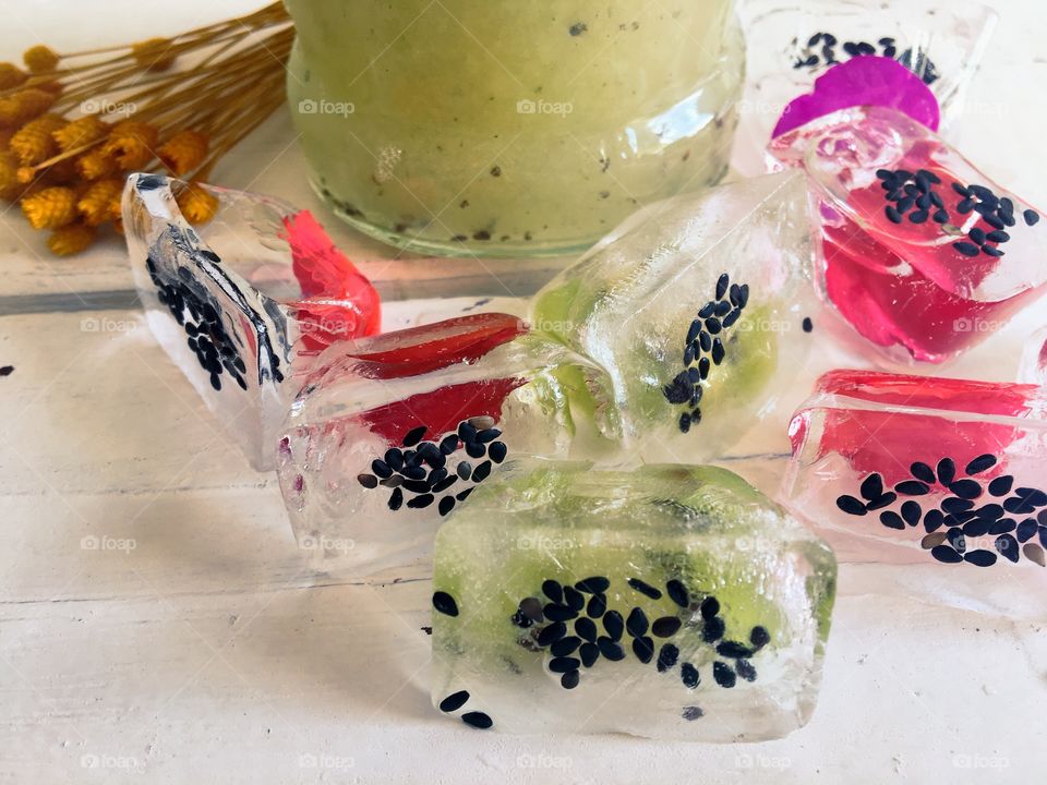 Kiwi juice and aromatic ice with fruit and flower petals