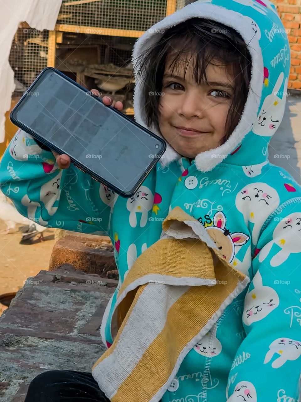 Cute little girl posing herself for photo with mobile