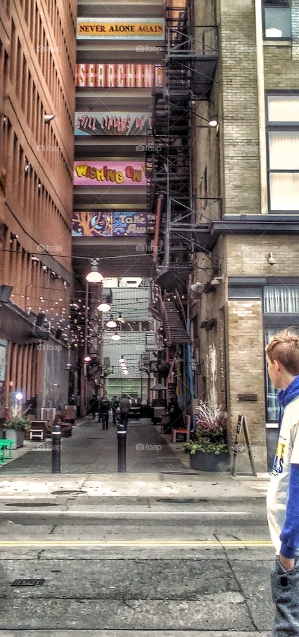 boy looking down graffitied alley