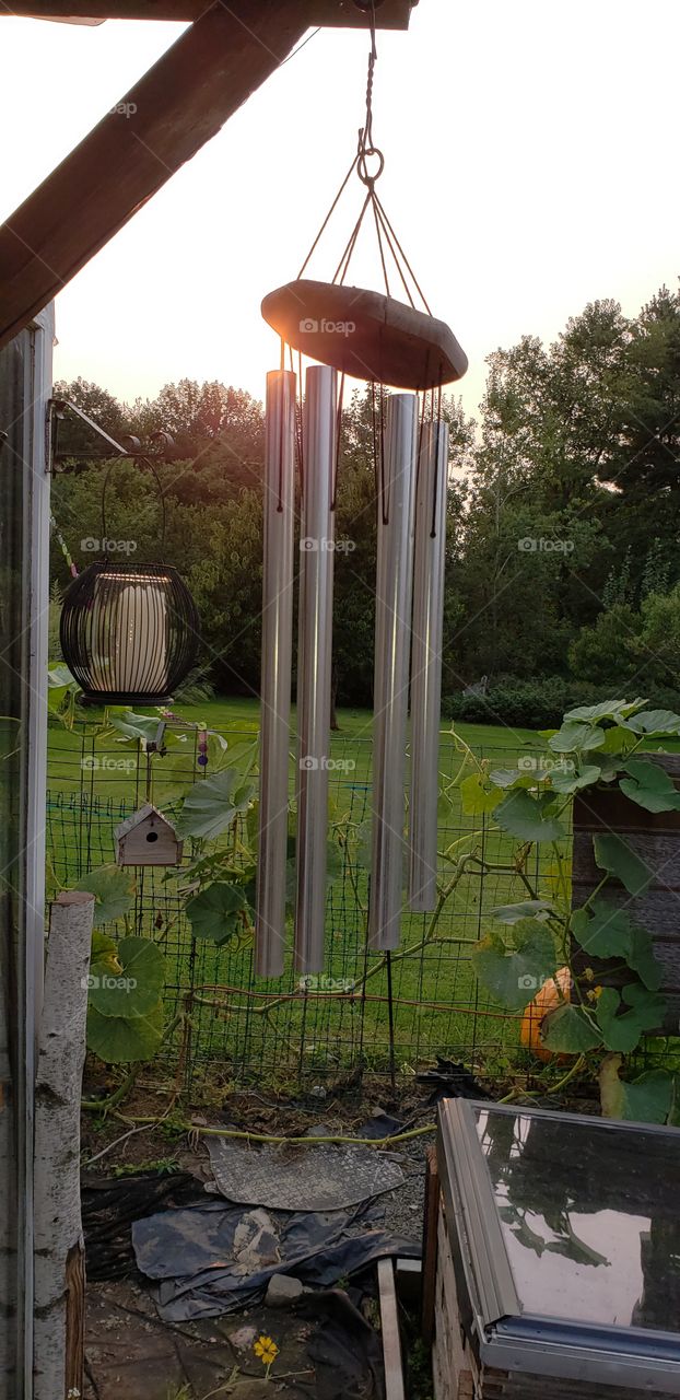 Windchime Hanging From Greenhouse in Garden