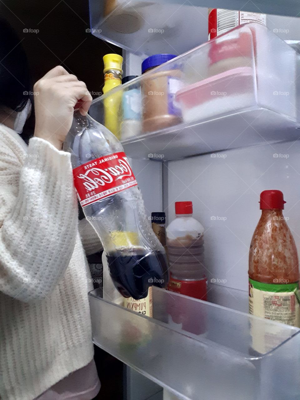 taking off the coca cola from refrigerator for a drink