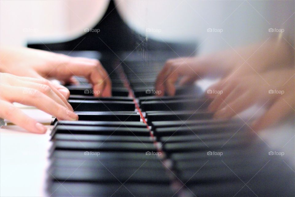 Close-up of a person's hand playing piano