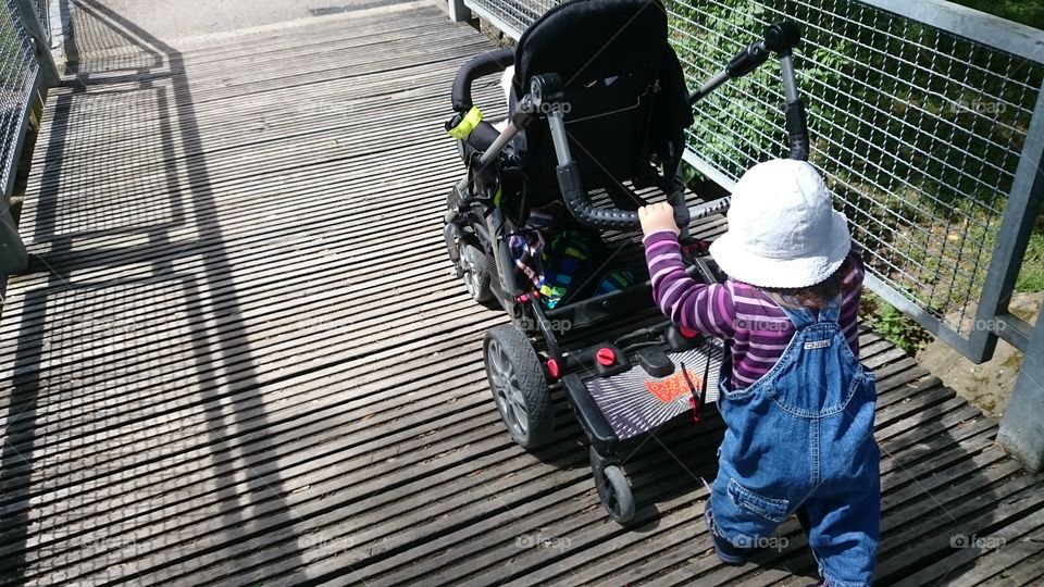 child pushing stroller
