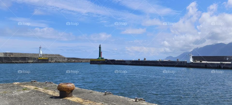 Lighthouse and blue sky with white clouds