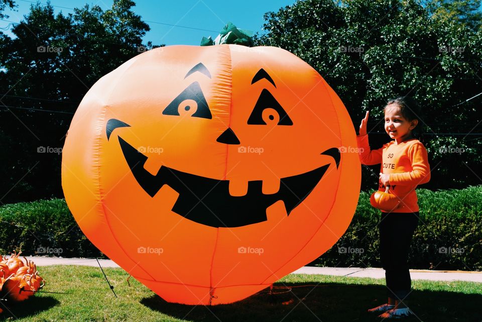 Girl holding inflatable large pumpkin