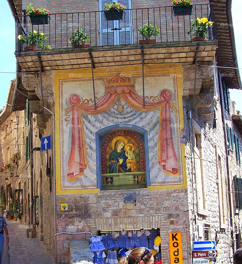 Street corner with religious icon mural at a crossroads in Siena, Italy