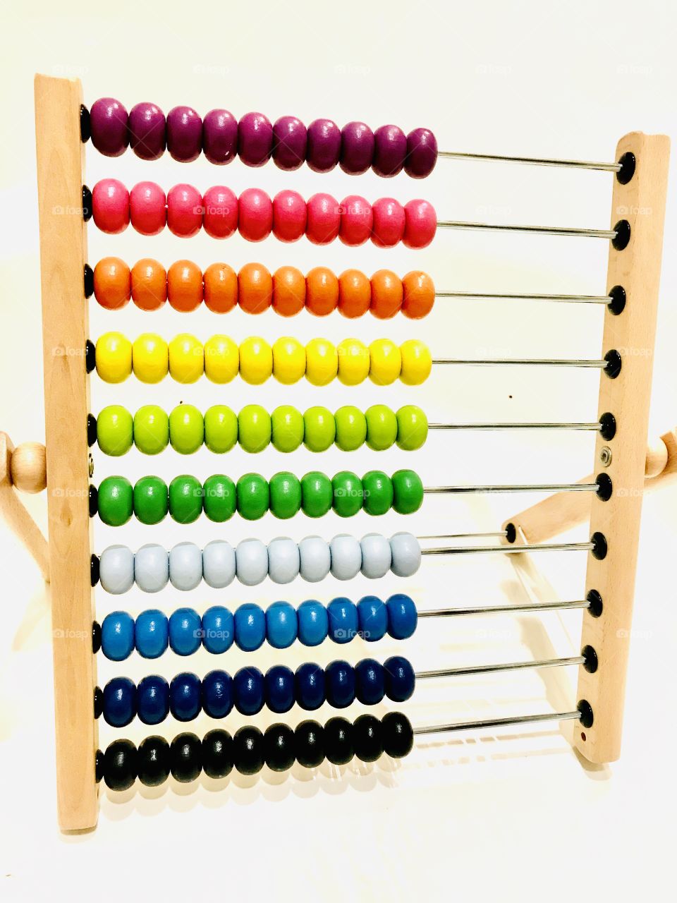 Gorgeous very colorful photo of rainbow colored abacus beads displayed against white background. 