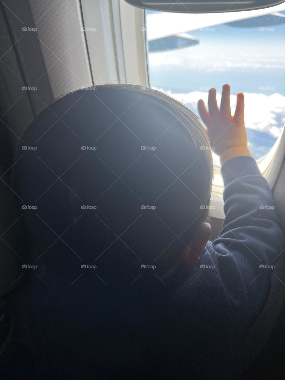 Baby looking out the window of airplane 