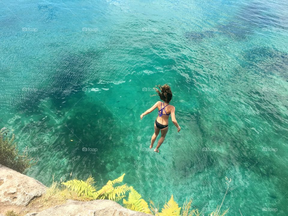Girl cliff jumping in New Zealand 