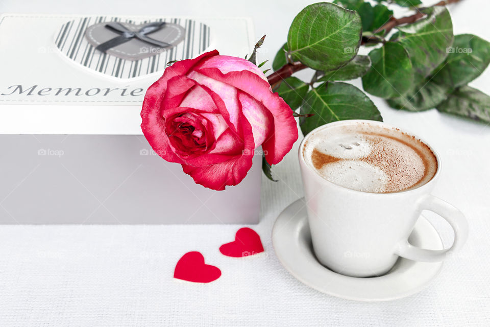 a cup of coffee and a rose