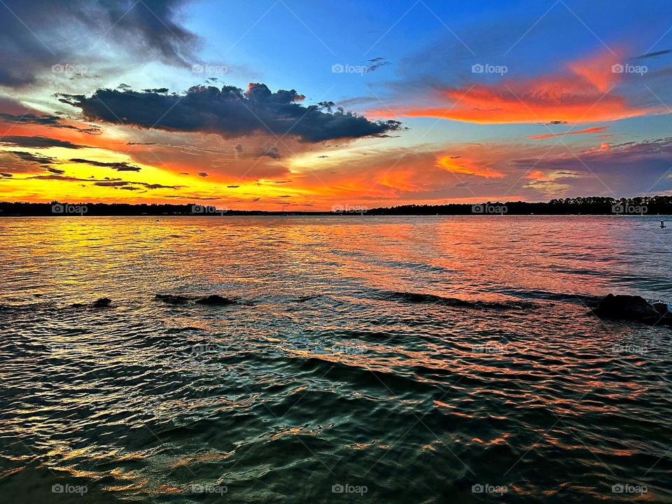 A breathtaking and radiant sunset colors the water and sky iridescent was glorious to behold and increasing every moment in splendor