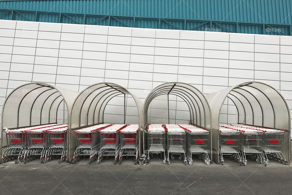 Shopping carts in front of shopping mall wall with geometric pattern 