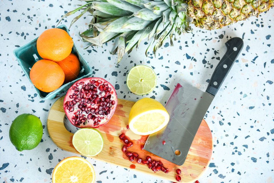 Flat lay of multiple fruits on a wooden cutting board