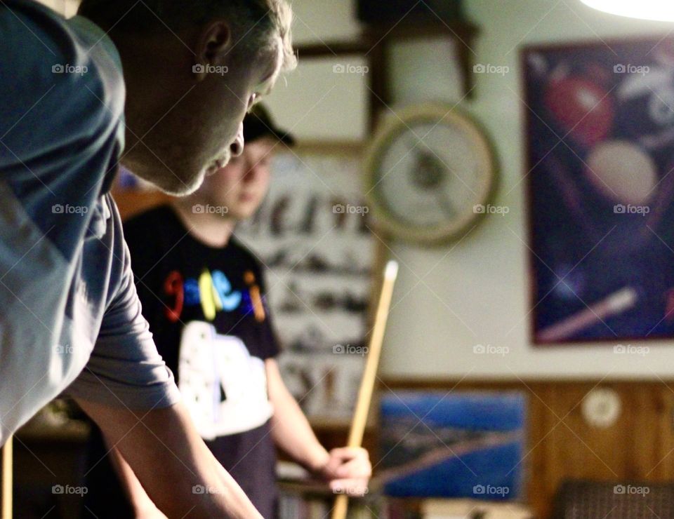 Father and son playin pool together.