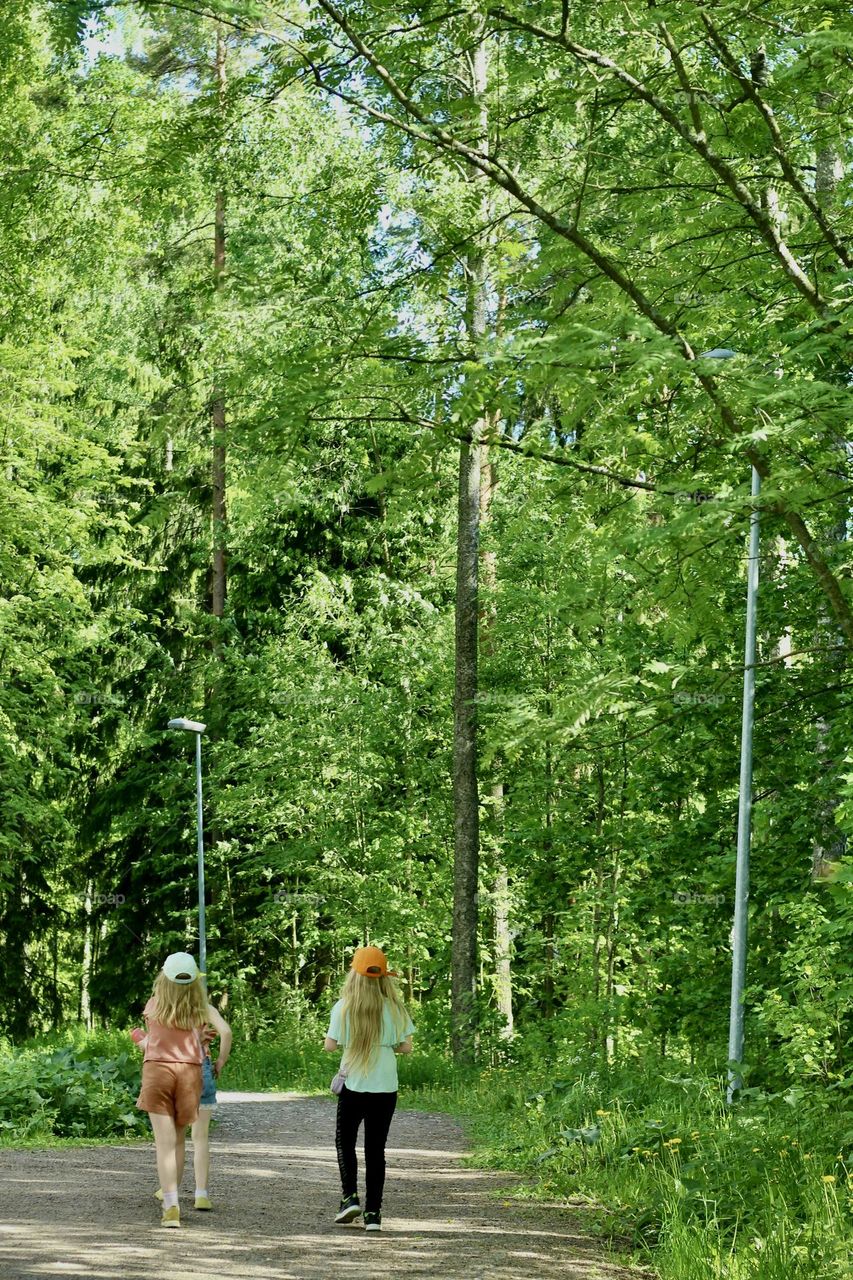 Little girls on a walk in forest path