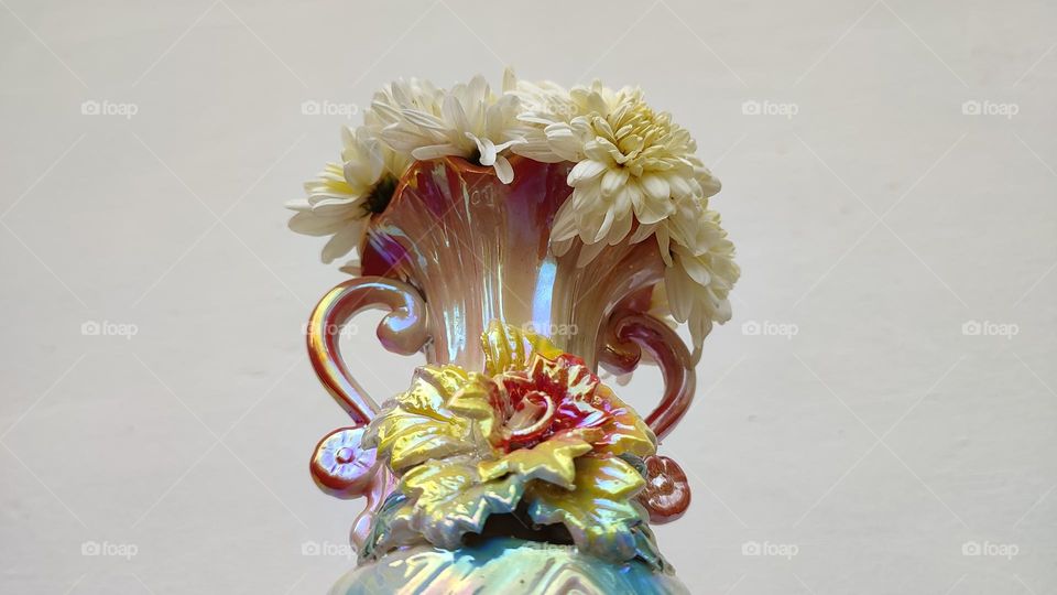 Beautiful white flowers in a colourful flowerpot with a flower sculpture, Flowers in a vase, colourful vase, white flowers in a vase