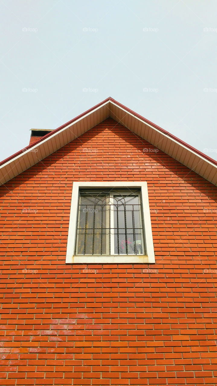 roof of a brick house with a window