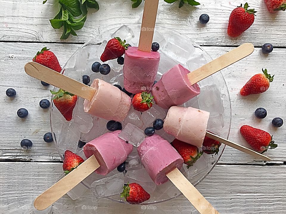 Homemade strawberry and black current yogurt ice lollies 