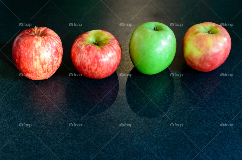 Row of different variety apples mixed red and green on black kitchen counter background with room for copy space 