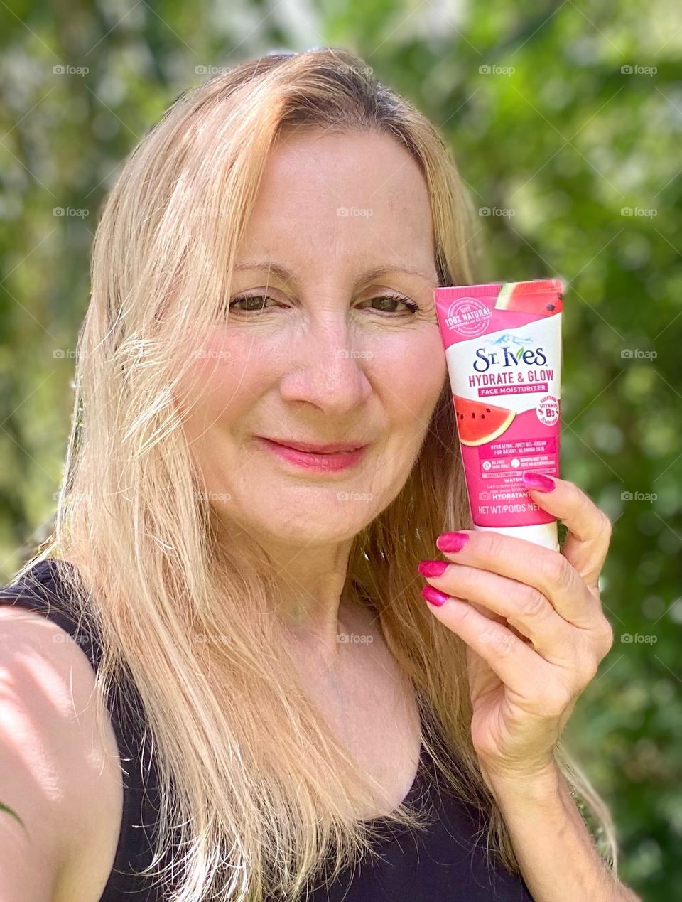 Woman holding a product from St. Ives