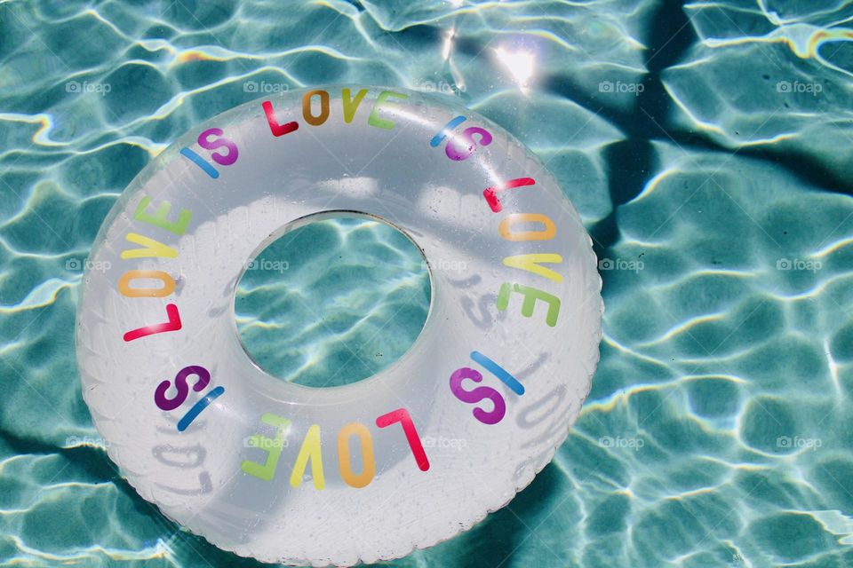 Love is love pool float in beautiful blue water